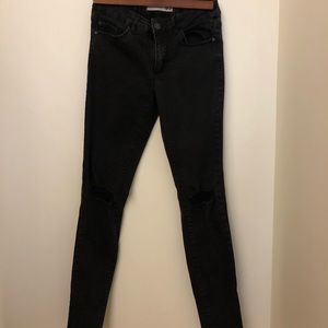 Mid waisted Black Garage jean, ripped in the knees
